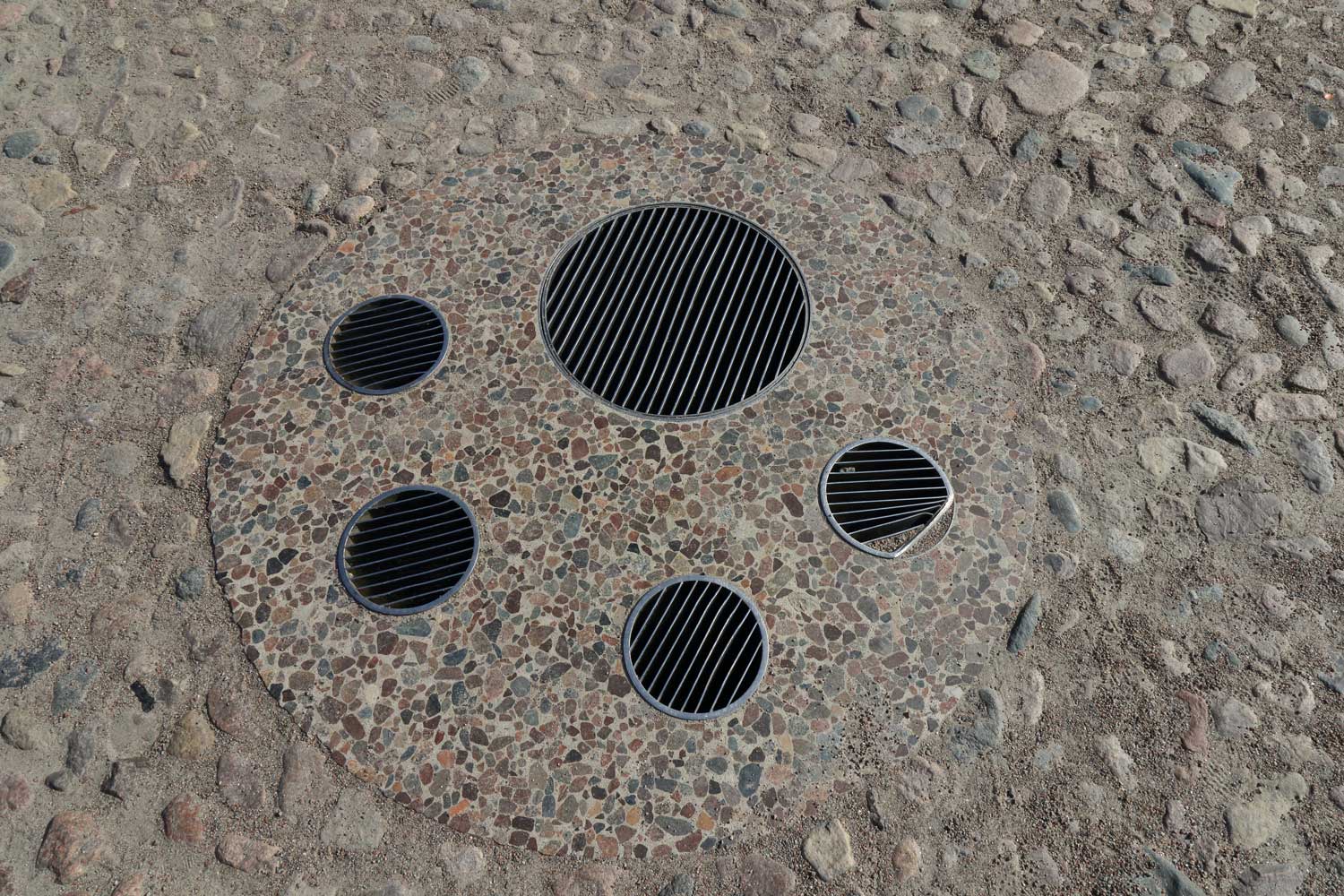 Nedsänkt brunn med sorl. Den gamla brunnen på torget har fått ett nytt utseende Foto: Stefan Svenaeus 2023